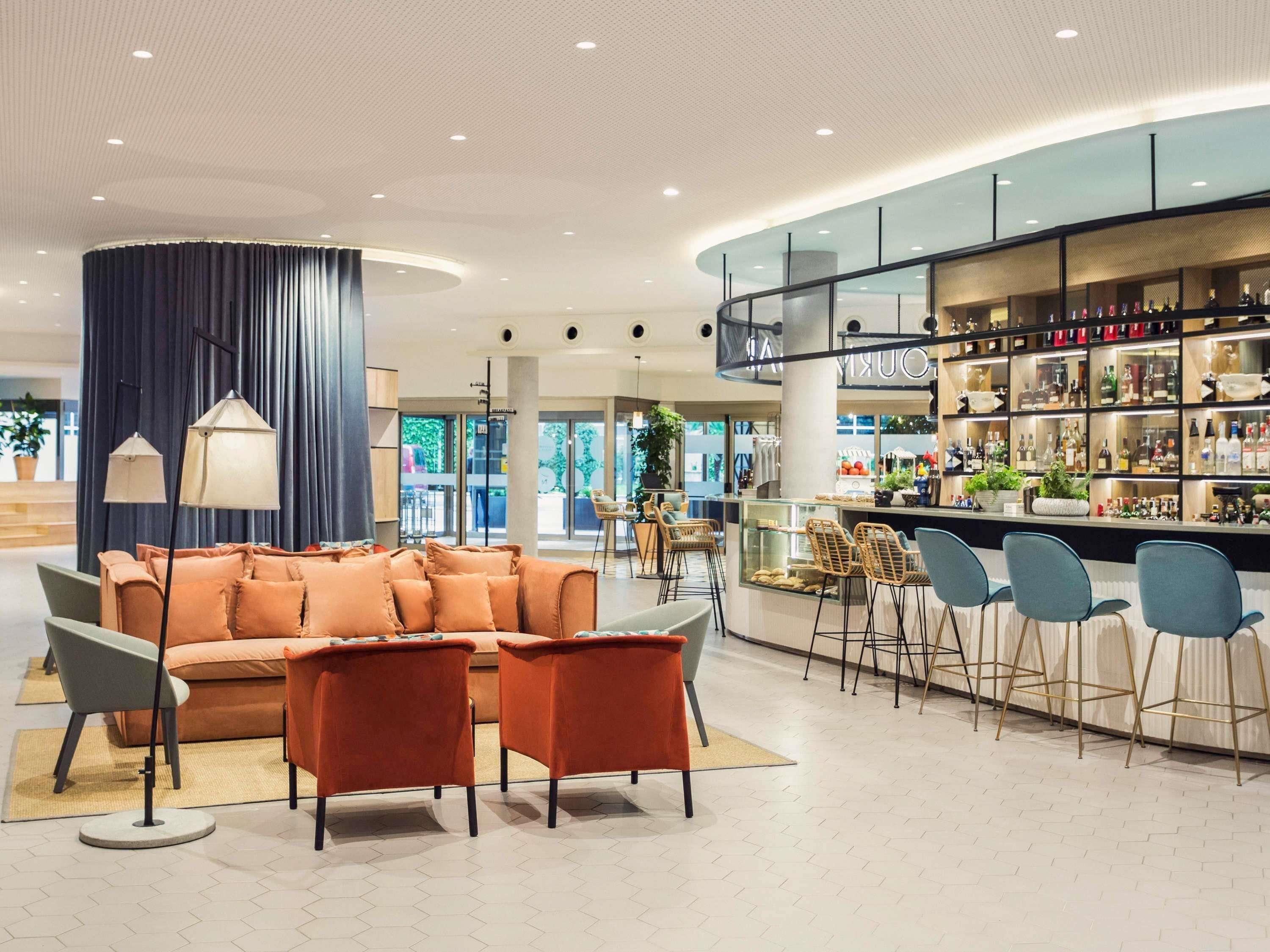 Un interior moderno con una zona de bar, asientos y vistas al exterior.