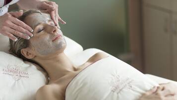 Una persona acostada en una cama con un almohadón que dice 'The Emporium Wellness & Beauty'.