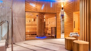 Un spa moderno con paneles de madera, entrada de vidrio y una zona de estar con toallas.