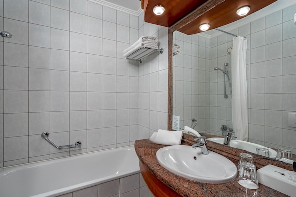 A bathroom with a white bathtub, a sink, a mirror, and a shower. - Ensana Thermal Hévíz (Hévíz)