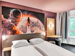 A hotel room with a large space-themed artwork on the wall, a bed with white linens, a bedside table, a nightstand, and a window with curtains. - B&B Hotel Bremen-Altstadt (Bremen)