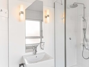 A modern bathroom with a glass-enclosed shower, a white sink, and two wall-mounted lights. - B&B Hotel Bremen-Altstadt (Bremen)
