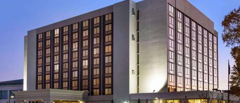 Un moderno edificio de hotel con una entrada destacada, varios pisos y un letrero que indica el nombre WYNDHAM.