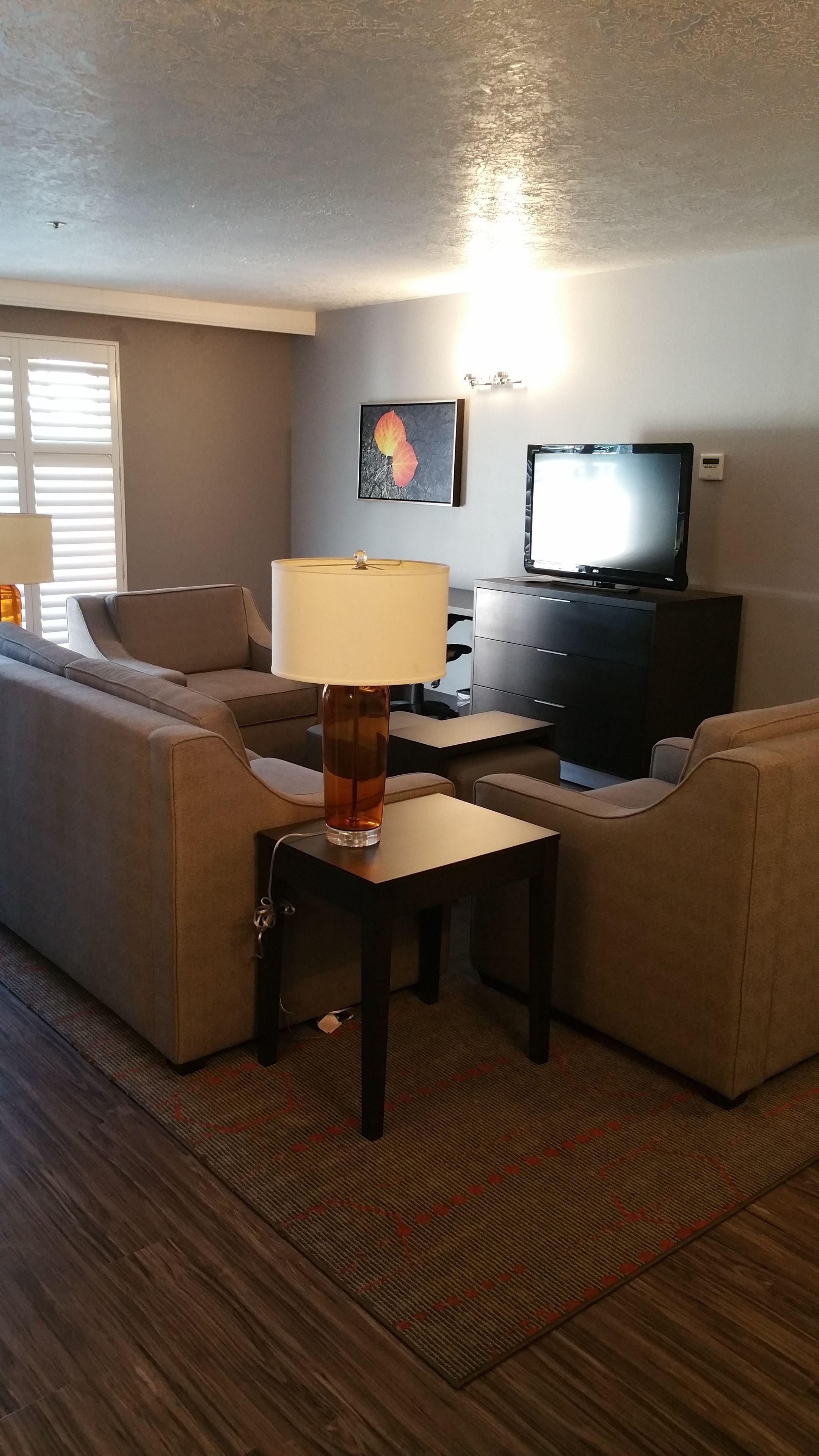A living room with a sofa, a coffee table, a lamp, a television, and a fireplace.