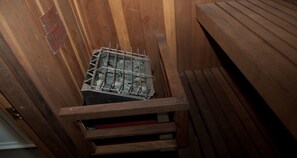A wooden sauna with a metal grate and benches. - Best Western Corvallis (Corvallis)