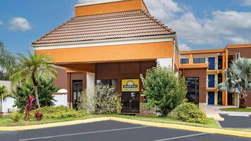 Um Days Inn com teto marrom, placa de identificação e estacionamento.