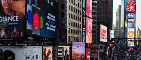 A cityscape with tall buildings and billboards, including one for Perry Ellis.