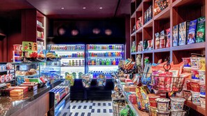 A grocery store with shelves stocked with various food items and a refrigerated section. - Renaissance New York Times Square Hotel by Marriott (New York)