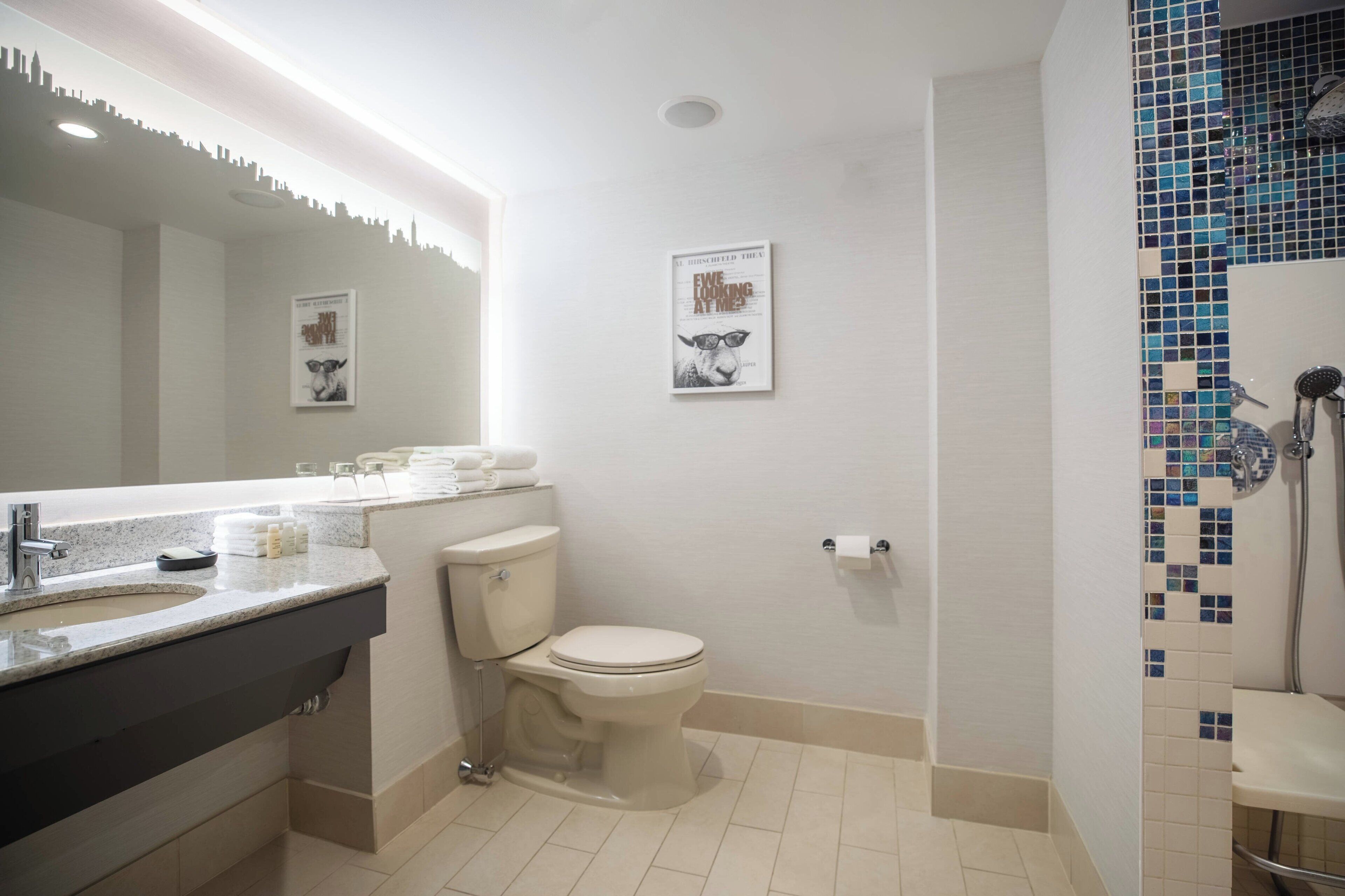 Een moderne badkamer met een wastafel, toilet en douche.