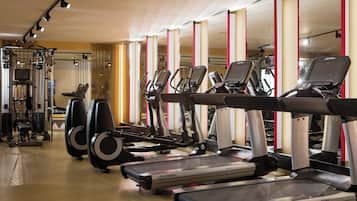Un gimnasio con cintas de correr, elípticas y máquinas de pesas.