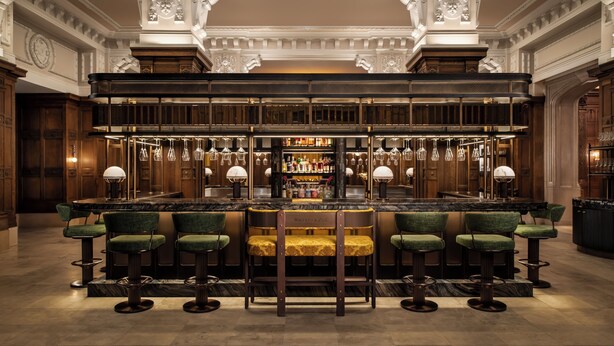 A bar area with a double-height bar, multiple stools, and a well-stocked liquor cabinet. - Fairmont Chateau Laurier (Ottawa)