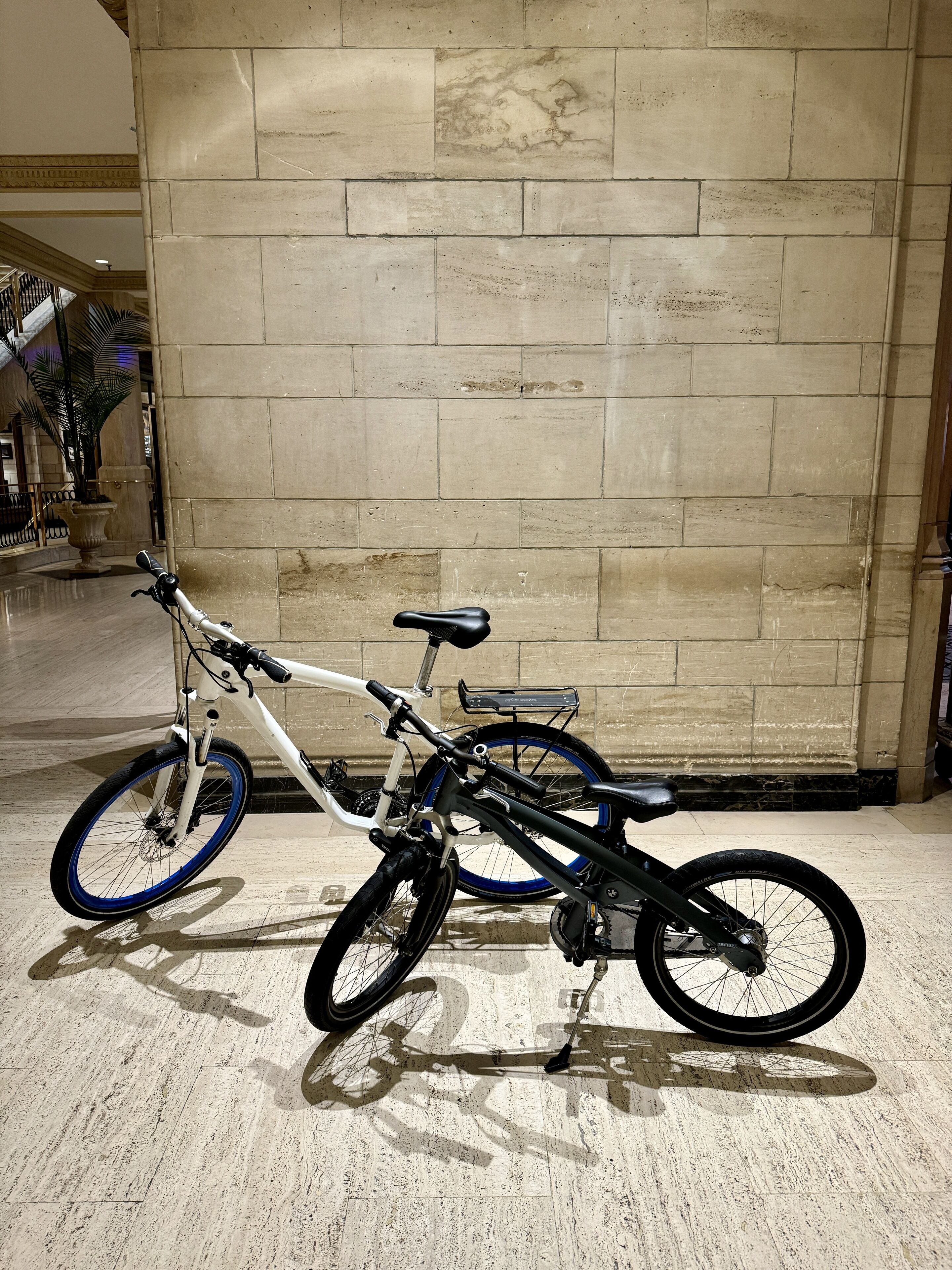 Una bicicleta apoyada en una pared con suelo de baldosas.