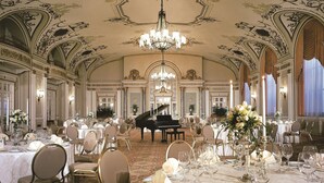 A grand ballroom with ornate ceiling decorations, a grand piano, and elegantly set tables. - Fairmont Chateau Laurier (Ottawa)