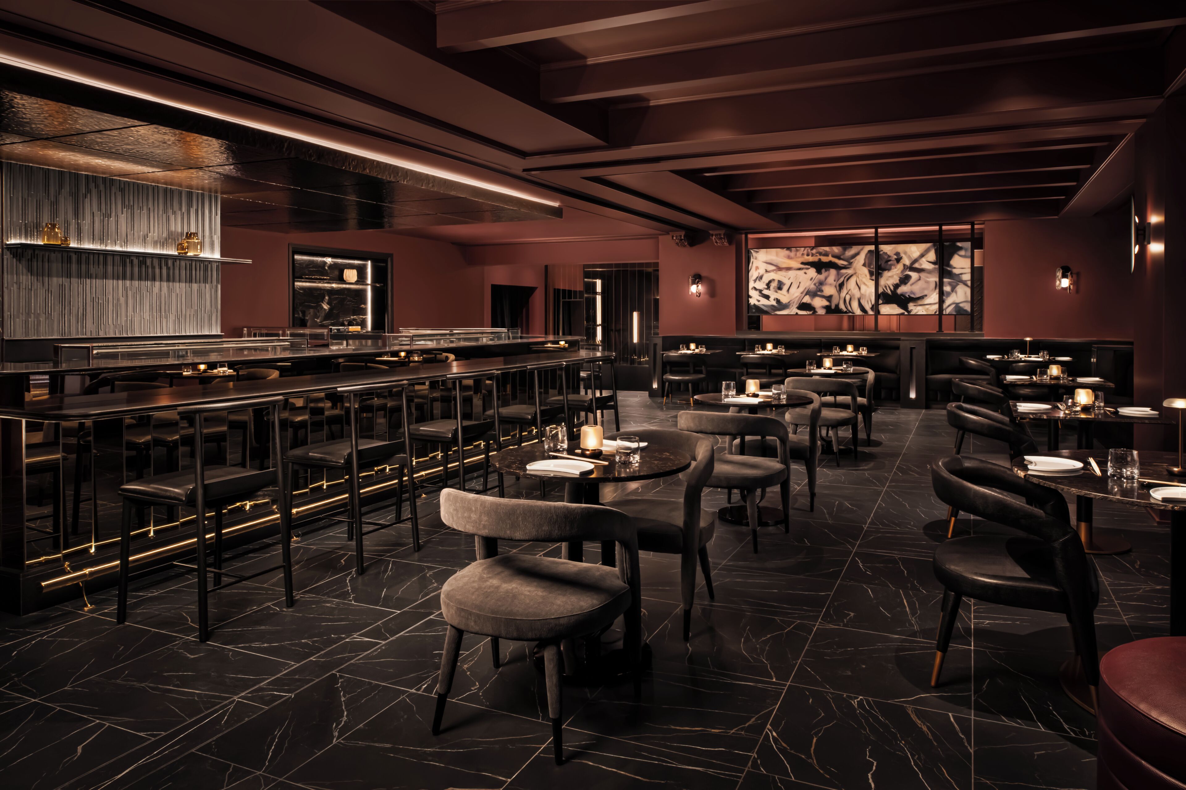 A modern restaurant with a bar area, seating arrangements, and a decorative wall.