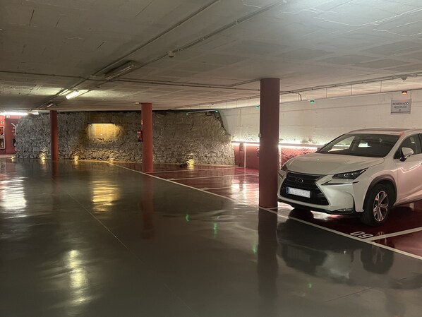 A parking garage with a white car parked in a spot marked '09'.