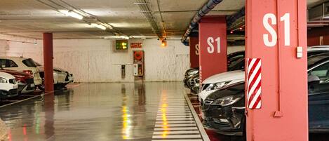 A multi-level parking garage with clearly marked parking spaces and directional arrows on the floor.