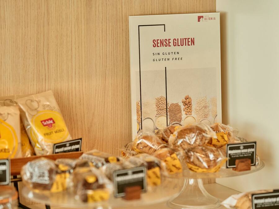 A display of gluten-free products including corn flakes and a sign for 'Sense Gluten' gluten-free items.