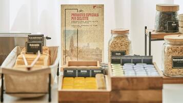 Una exhibición de refrigerios y productos para ciclistas, que incluye barras energéticas y frutas deshidratadas, con un cartel en español y francés.