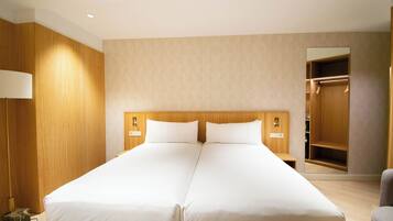 A double bed with a wooden headboard, a bedside lamp, and a mirror on the wall.