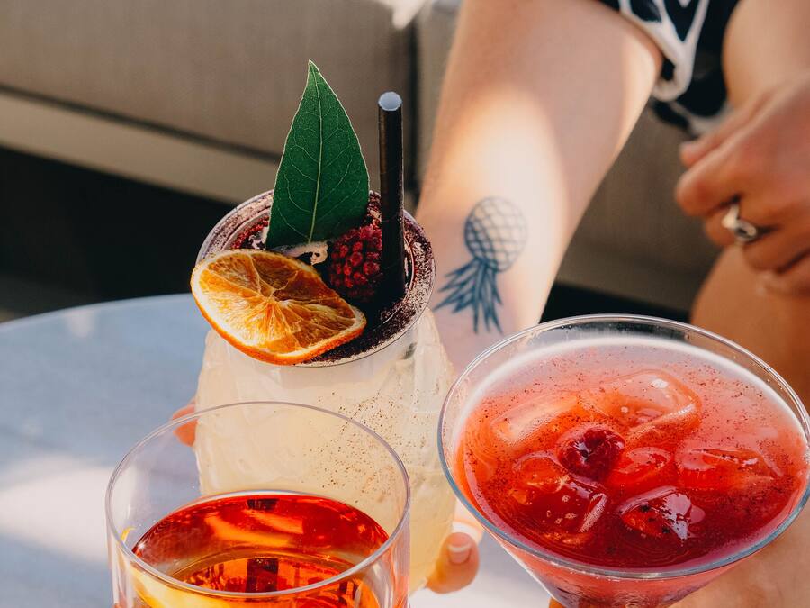 Dos bebidas sobre una mesa, una persona sostiene una de ellas.