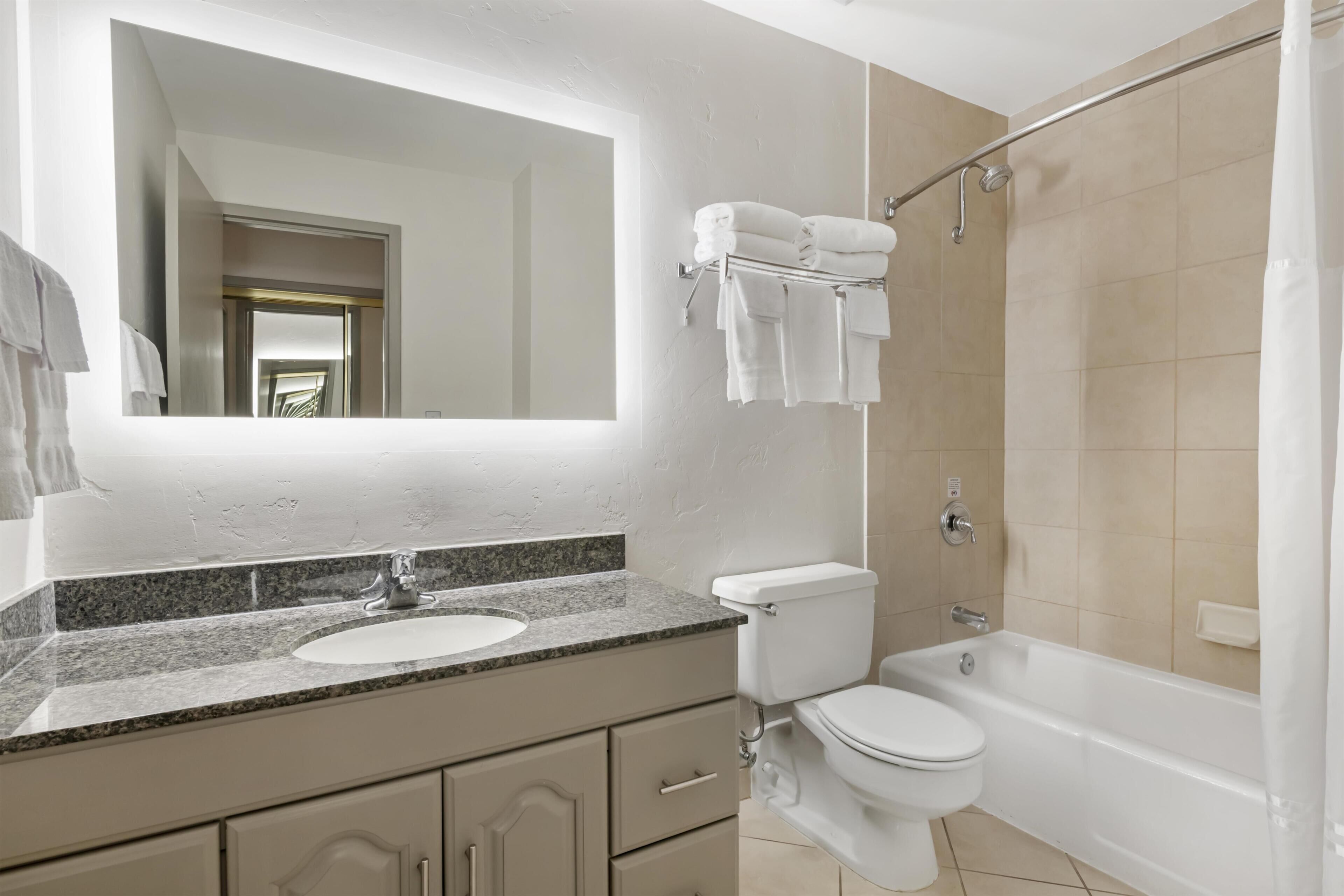 Un baño con lavamanos, inodoro y bañera.
