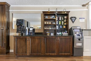 A hotel reception area with a coffee machine, a self-service kiosk, and a variety of snacks and toiletries on shelves. - Best Western Plus Burley Inn & Convention Center (Burley)