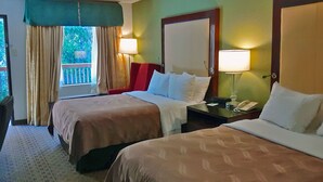 A hotel room with two beds, a desk, a chair, a lamp, and a window with curtains. - Quality Inn Morganton Southeast (Morganton)
