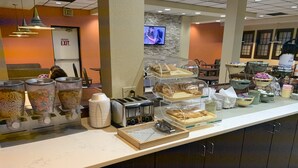 A breakfast buffet area with cereal containers, a toaster, and various food items on display. - Quality Inn Morganton Southeast (Morganton)