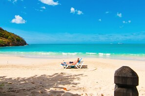 On the beach, white sand, sun loungers, beach umbrellas