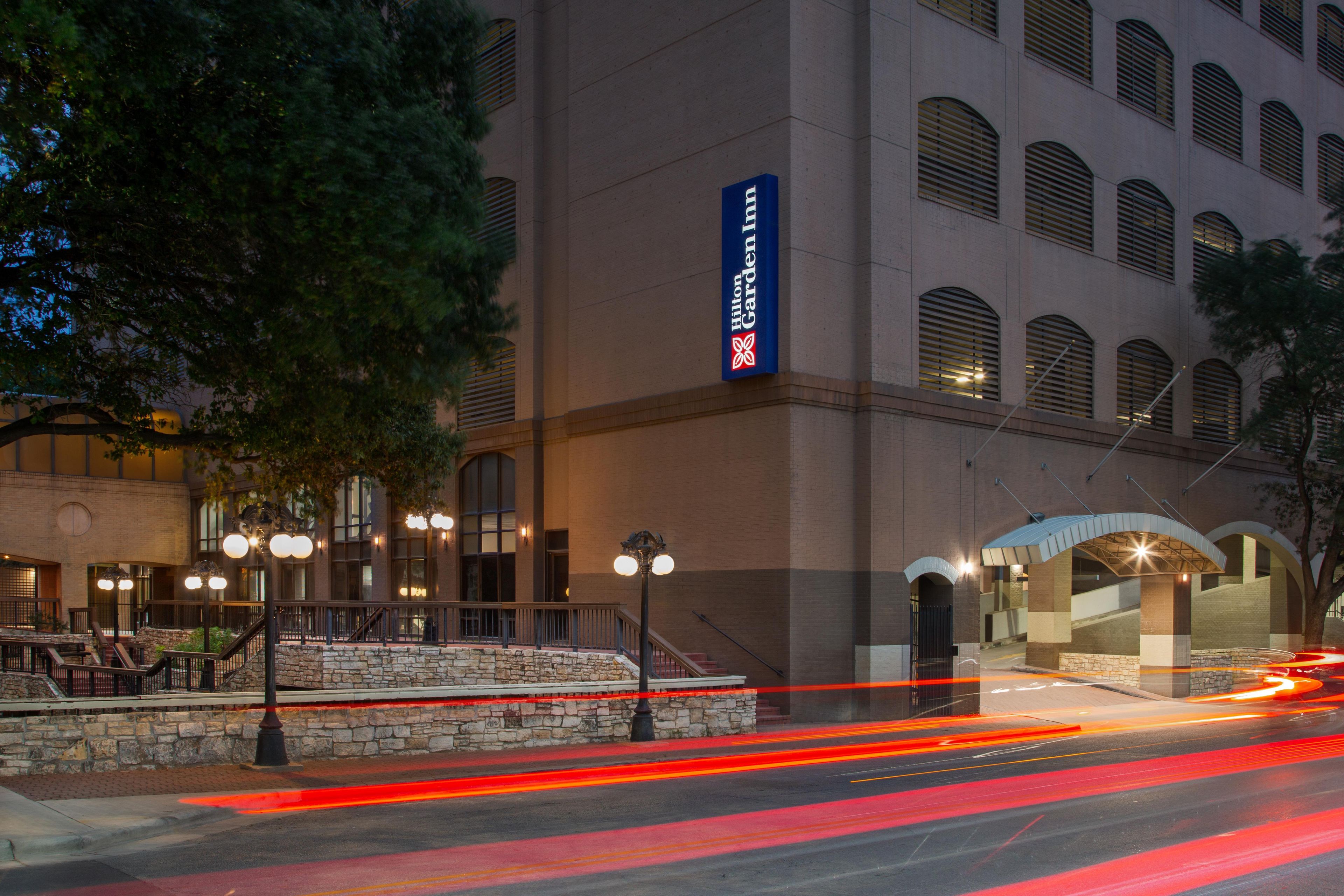 A hotel with a prominent sign, a stone facade, and a well-lit entrance.