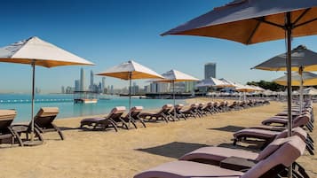 On the beach, white sand, beach towels, beach bar
