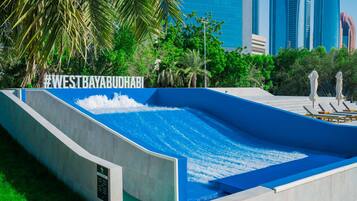 Een waterglijbaan bij West Bay Abu Dhabi, met moderne gebouwen op de achtergrond.