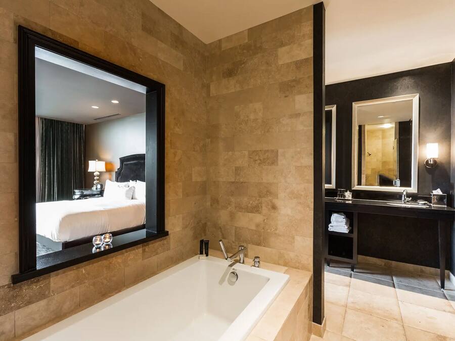 A modern bathroom with a large bathtub, a vanity with a mirror, and a shower area.