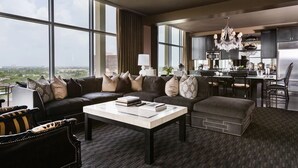 A modern hotel room with a large window, a sofa, a coffee table, and a dining area. - Hotel Zaza Houston Museum District (Houston)