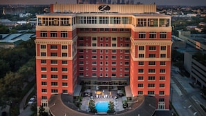 A high-rise hotel with a rooftop pool, multiple floors, and a city skyline in the background. - Hotel Zaza Houston Museum District (Houston)