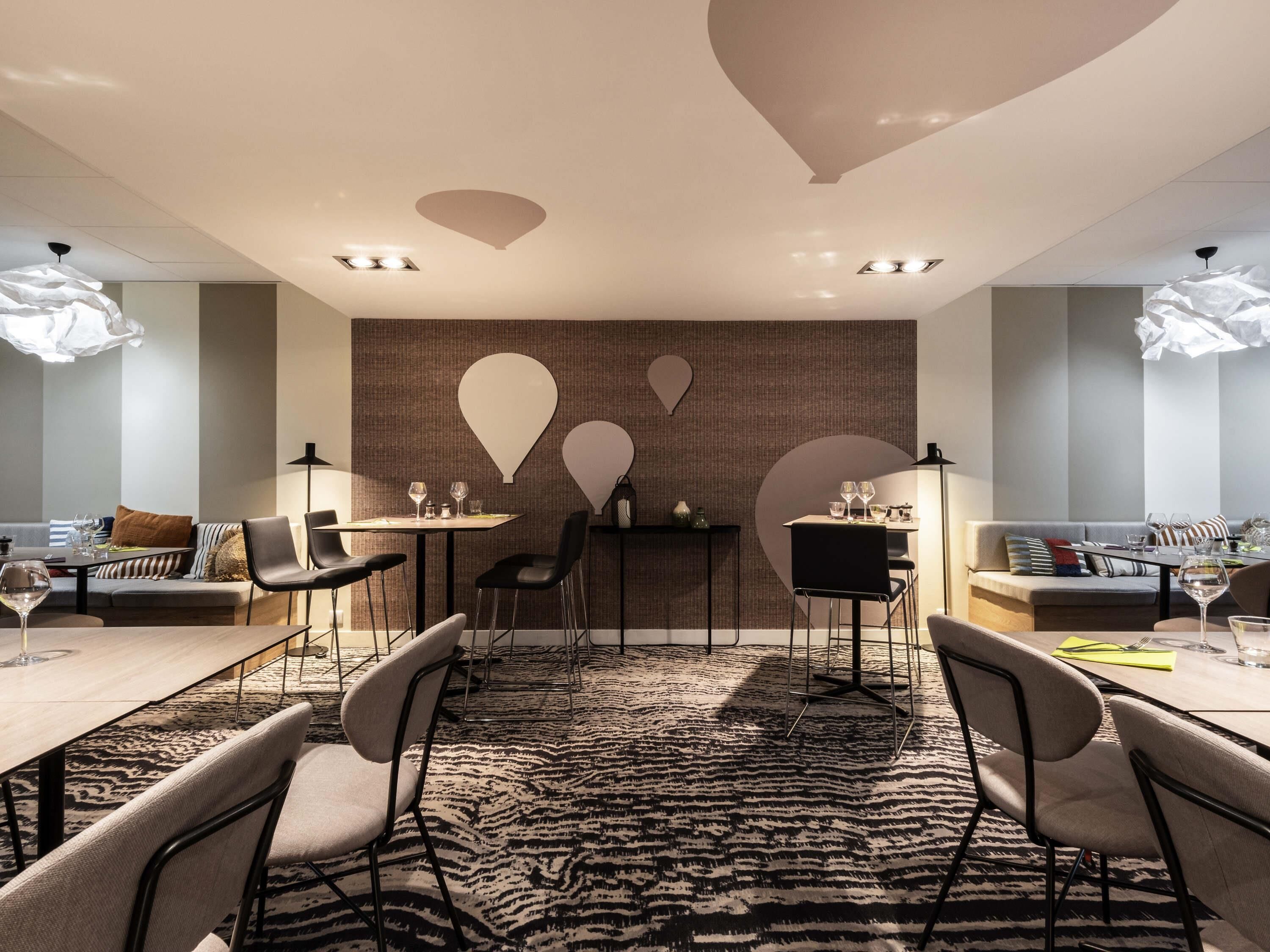 A modern conference room with a patterned carpet, black chairs, and tables set for meetings.