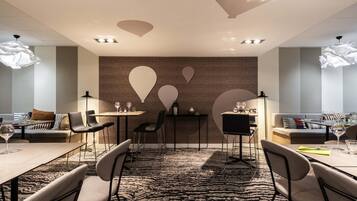 A modern conference room with a patterned carpet, black chairs, and tables set for meetings.