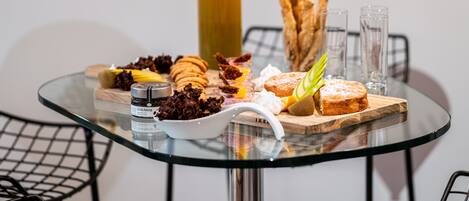 A glass table with a variety of pastries and a bottle of juice.
