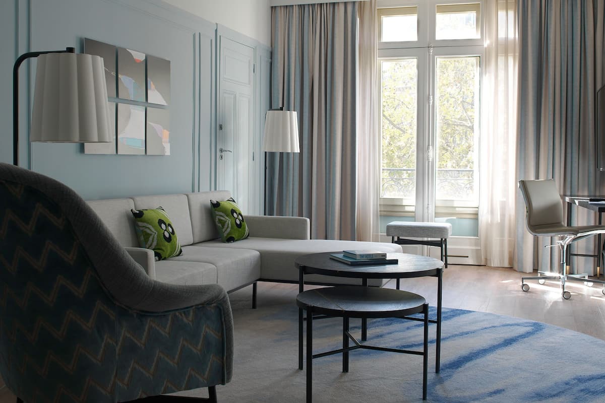 A modern living room with a sectional sofa, a round coffee table, and a grey armchair.