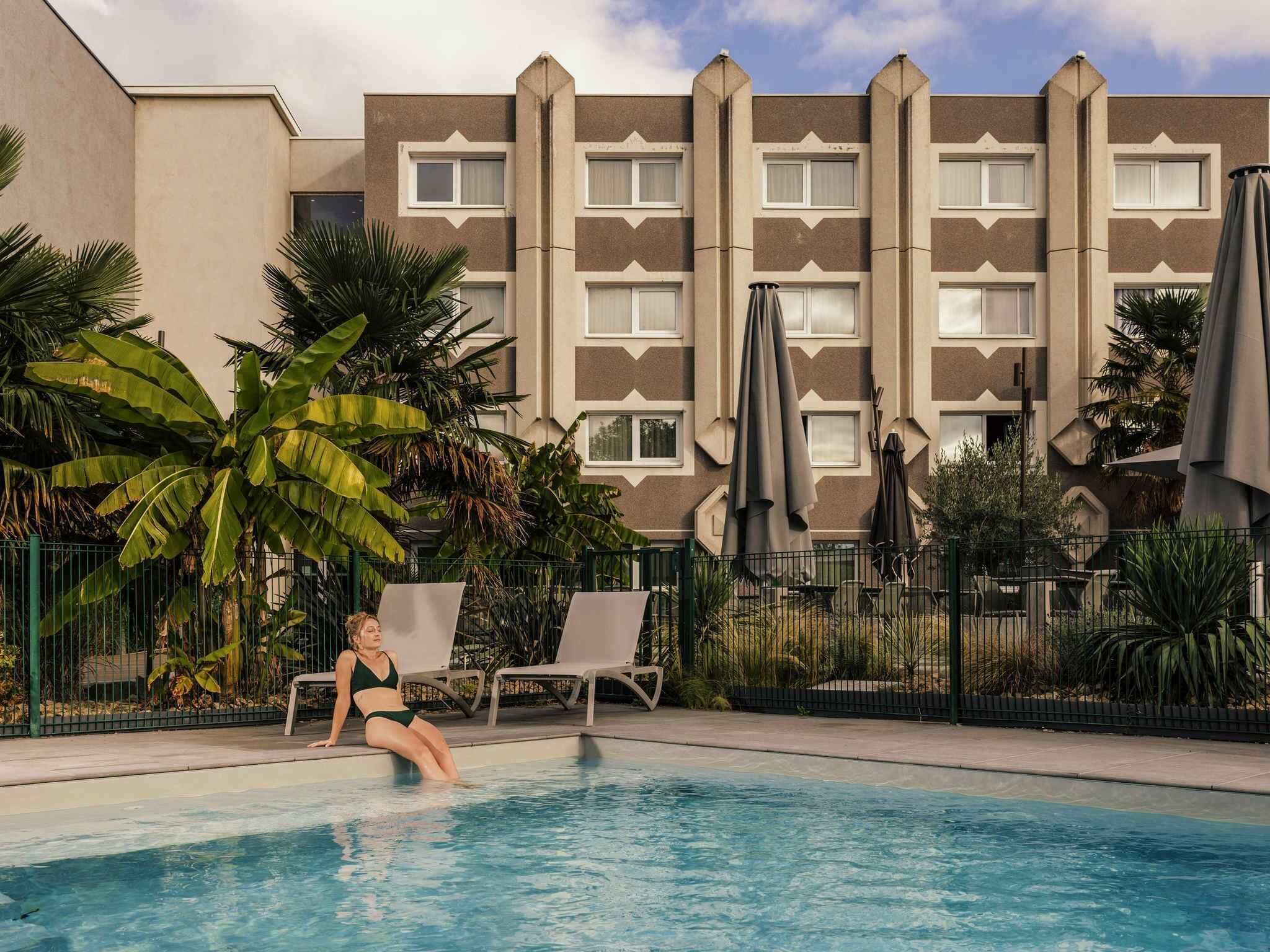Una piscina al aire libre de temporada, sombrillas
