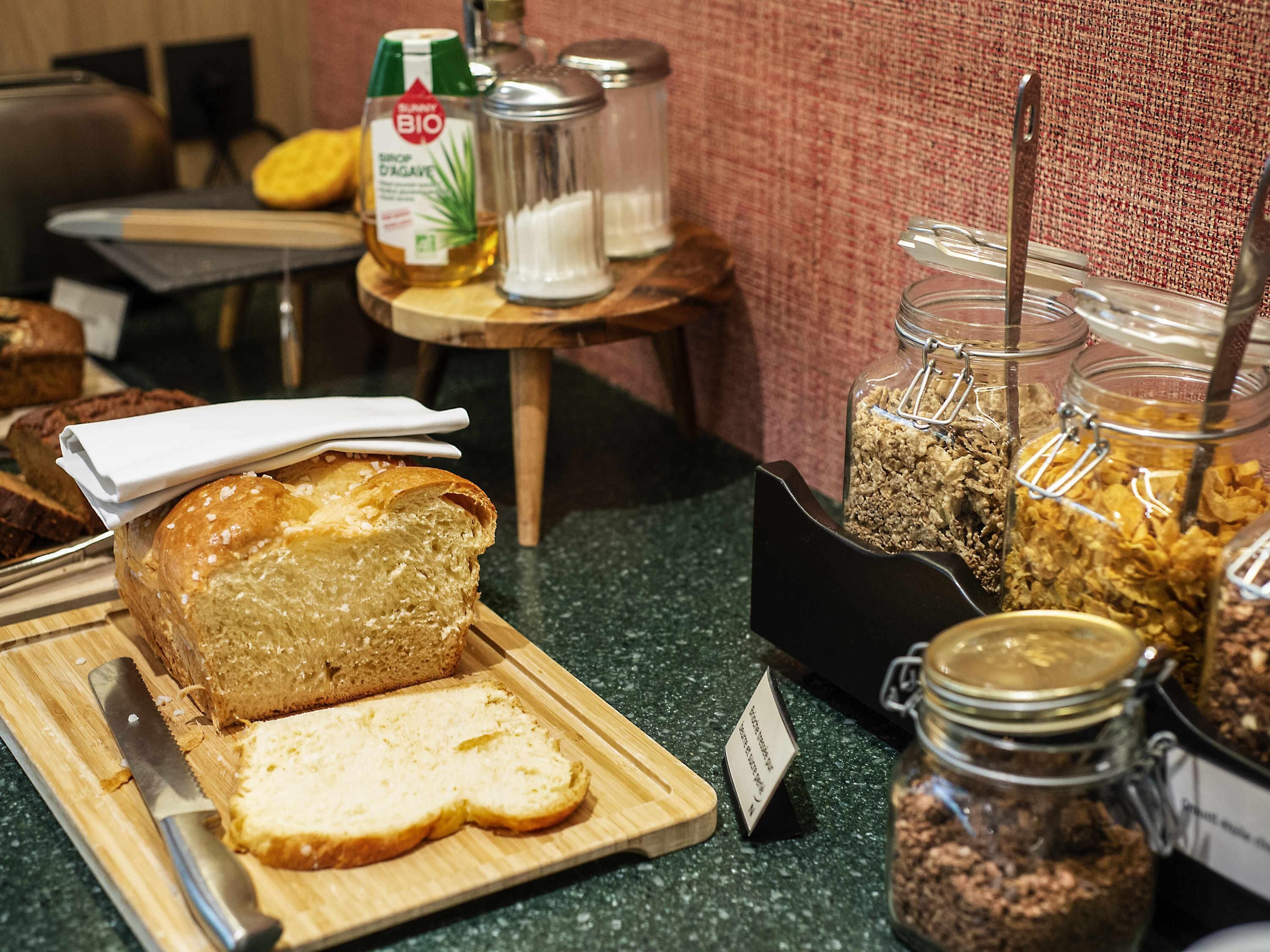 Un buffet de petit-déjeuner comprenant du pain, des céréales et diverses garnitures.