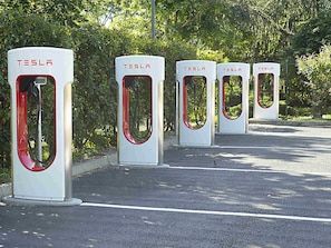 Four Tesla electric vehicle charging stations in a row.
