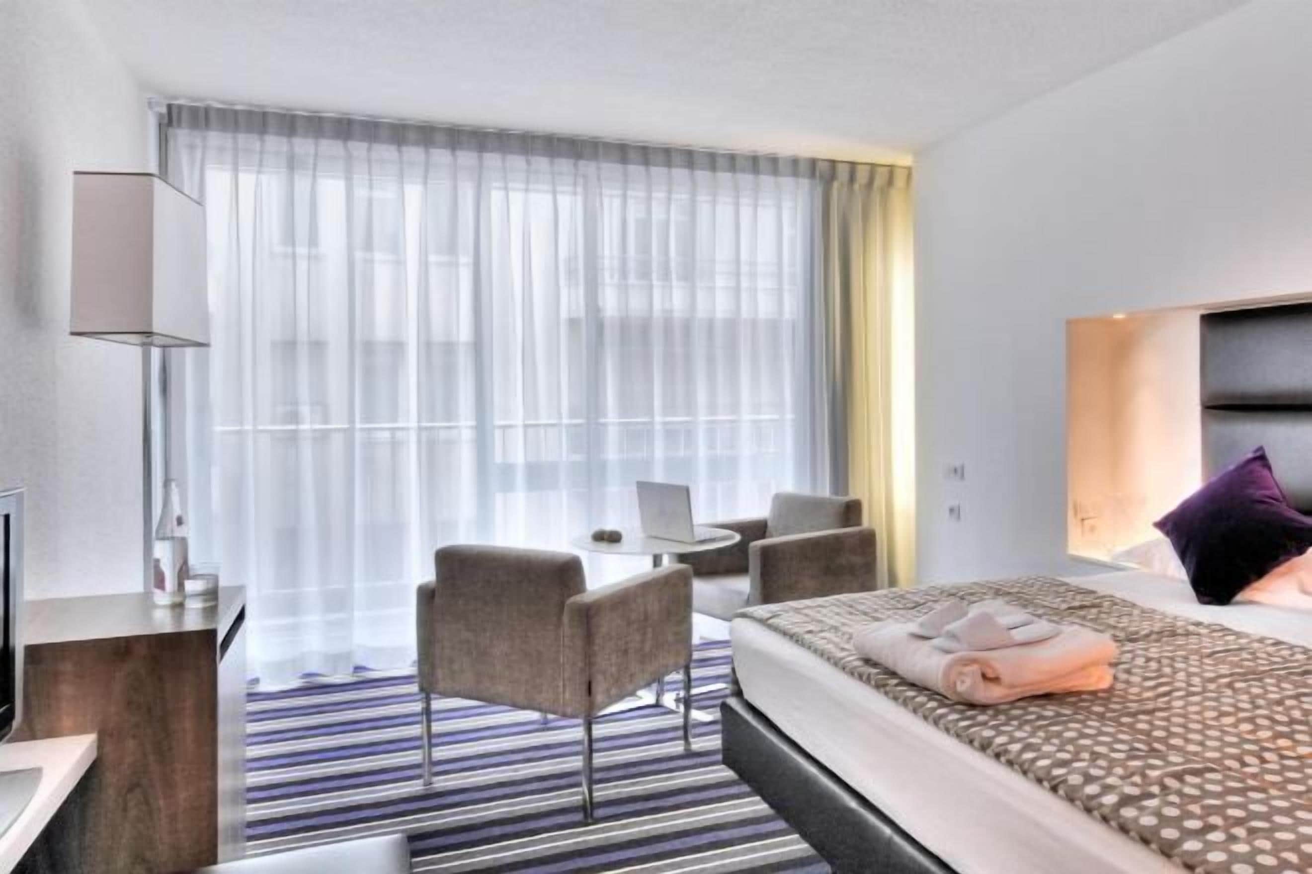 Ropa de cama de alta calidad y caja de seguridad en la habitación 