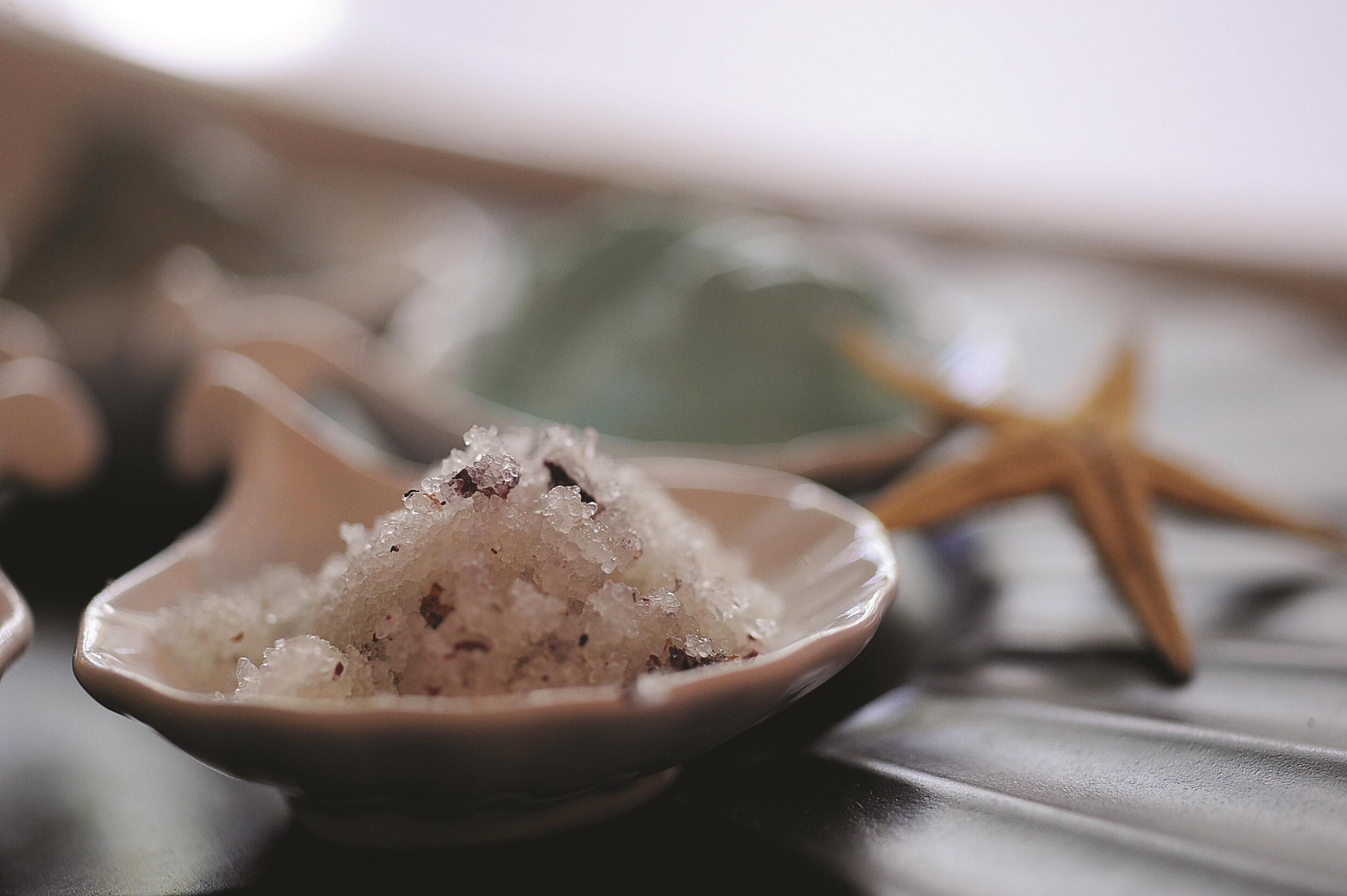 A bowl of salt with a starfish in the background.