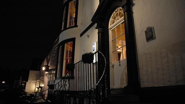 A white building with arched windows and a black iron railing. - Donington Manor Hotel (Derby)
