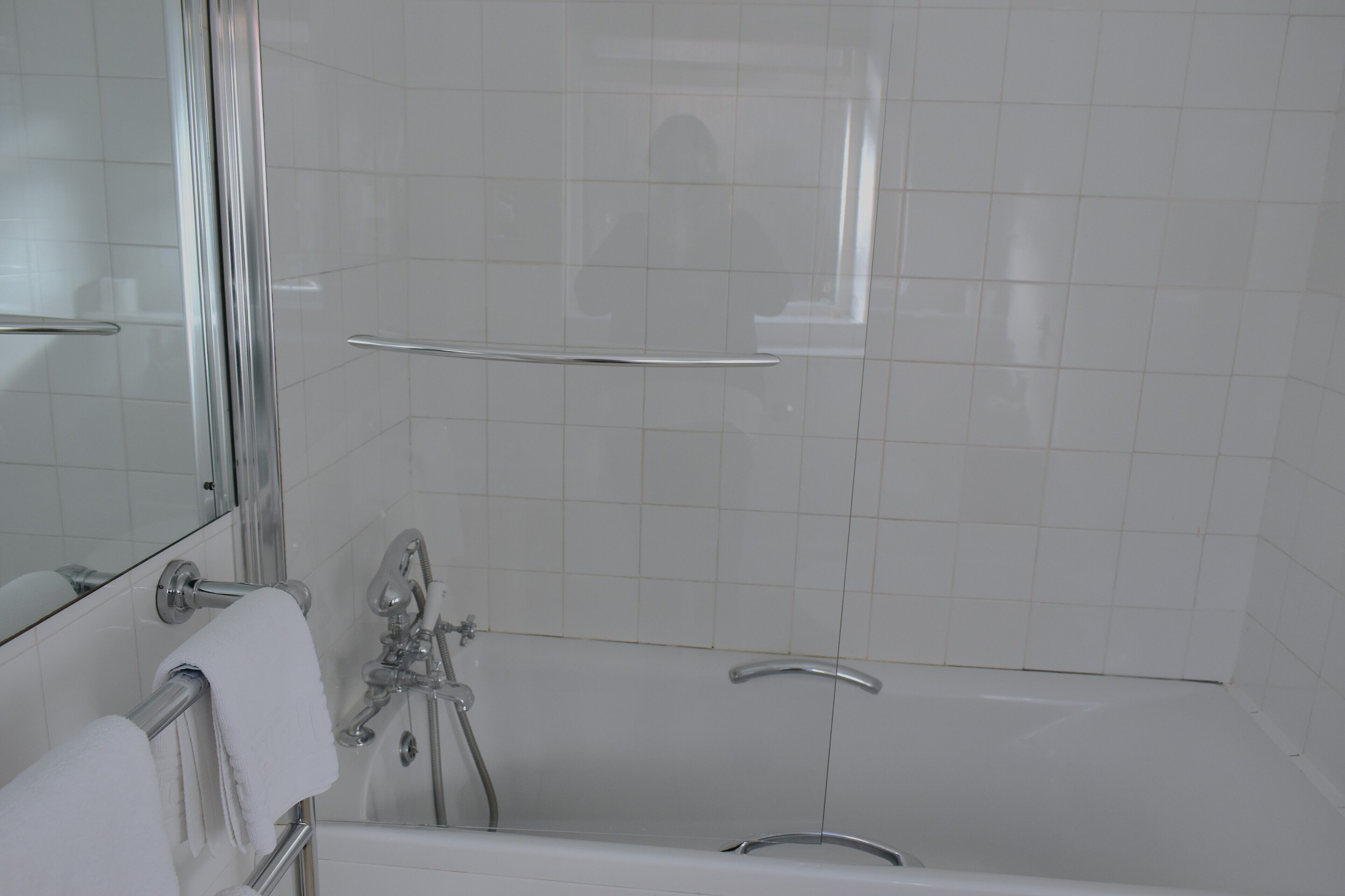 A modern bathroom with a bathtub, a shower, and a toilet.