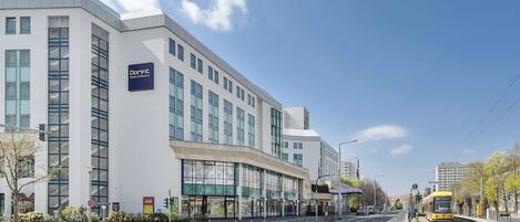 A modern hotel with a prominent Dorint sign, large windows, and a clean, urban street view.