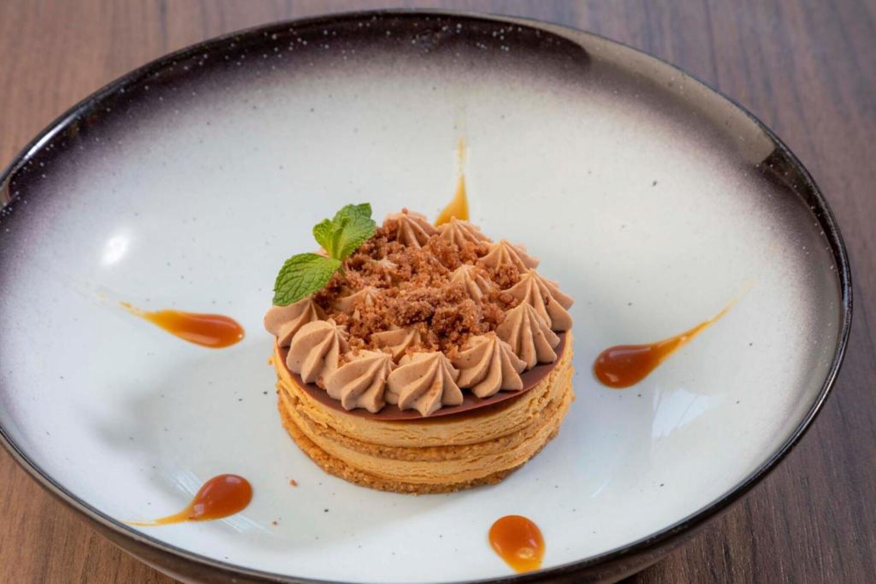 Un postre en un plato con adorno de menta.