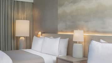 A hotel room with a bed, bedside tables, lamps, and a textured wall.