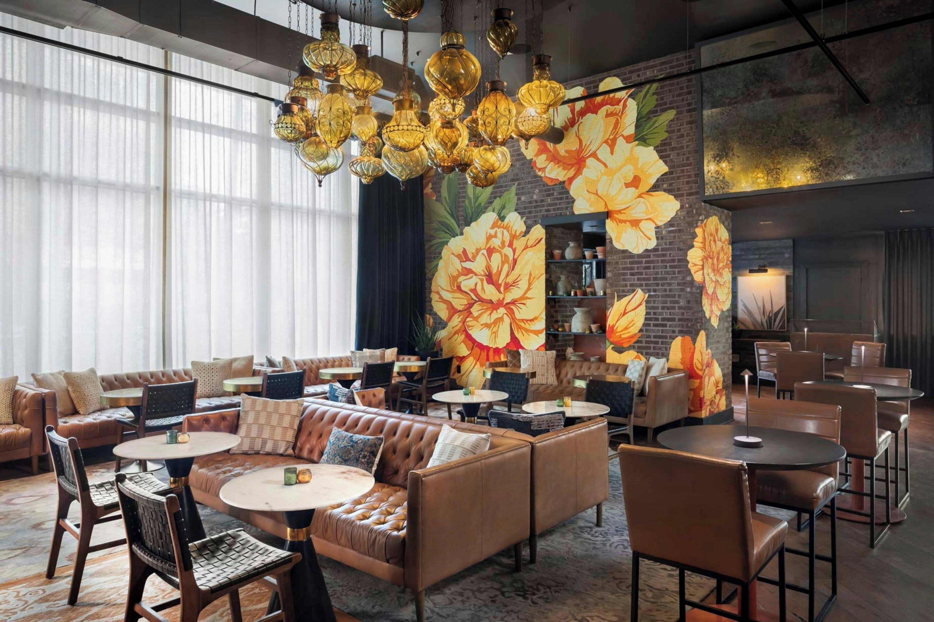 A modern interior with leather sofas, round tables, and hanging lamps.